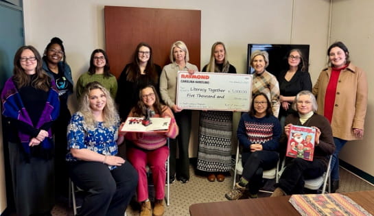 Carolina Handling presents check to Literacy Together staff